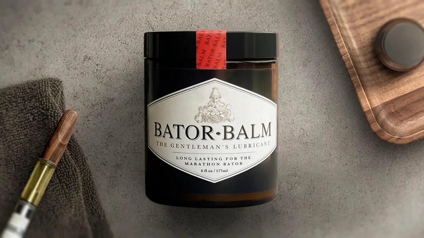 Bator Balm jar with a vape and towel on a textured surface