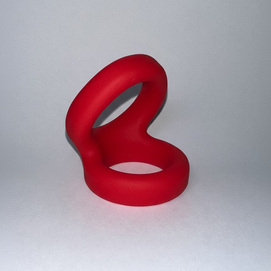 Red silicone penis ring on a white background