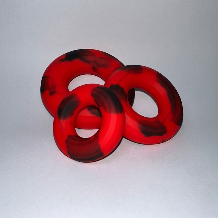 Red and black penis rings on a white background